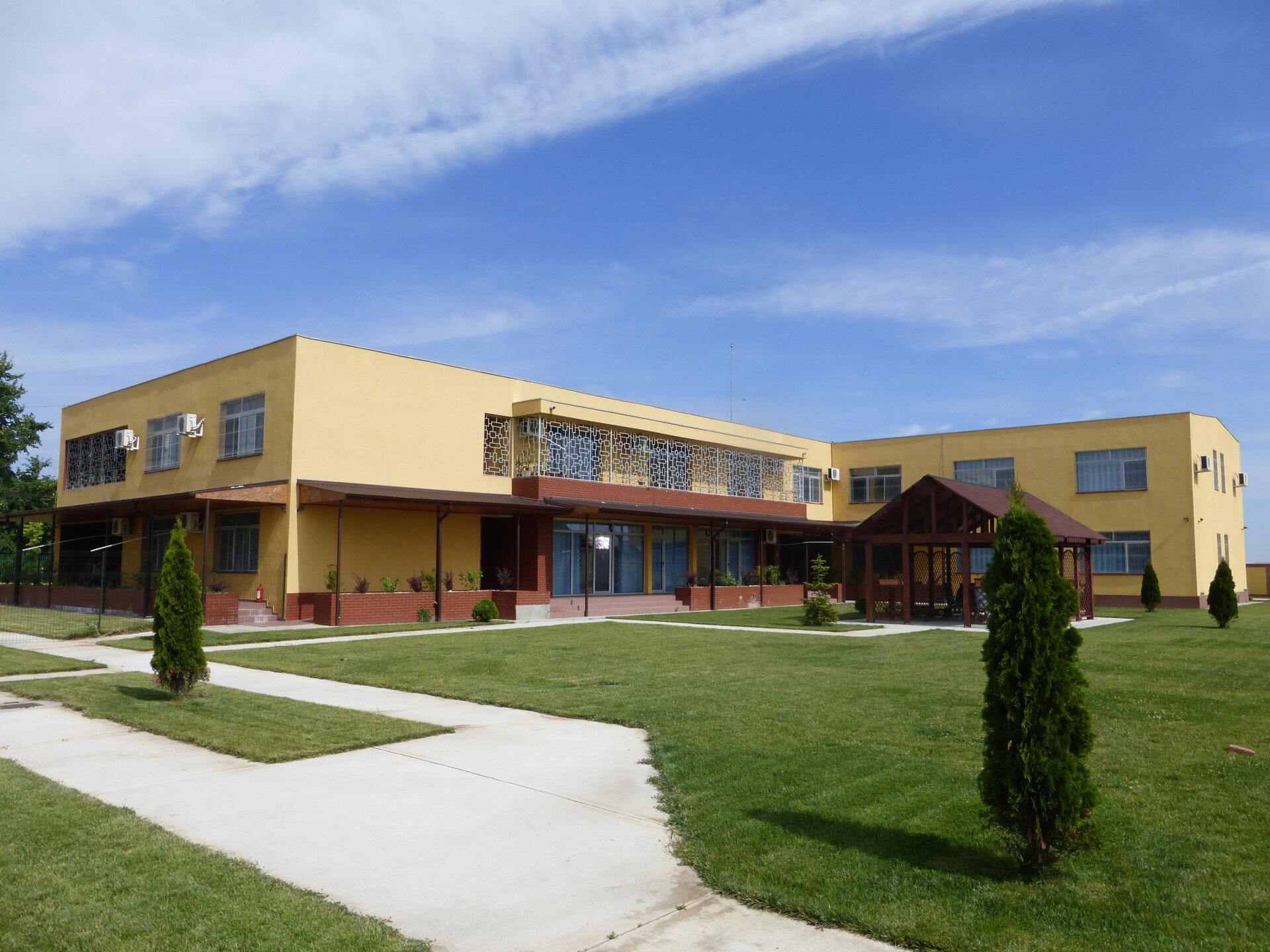 Vedere de ansamblu a curții interioare a Centrului de Reabilitare și Recuperare Neuropsihică Uverturii Sector 6, cu terase, alei pietonale, gazon și foișor de relaxare, proiect PPAE finalizat în 2012