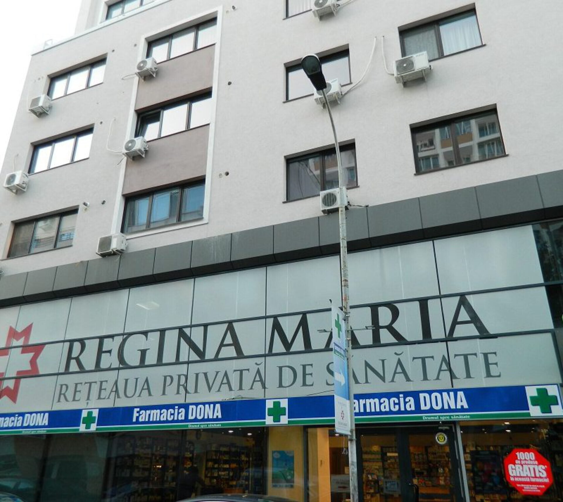 Fațadă lungă centru medical Regina Maria Hatmanul Arbore cu firmă pe toată lungimea parterului și Farmacia DONA în zona dreaptă, proiect PPAE de amenajare
