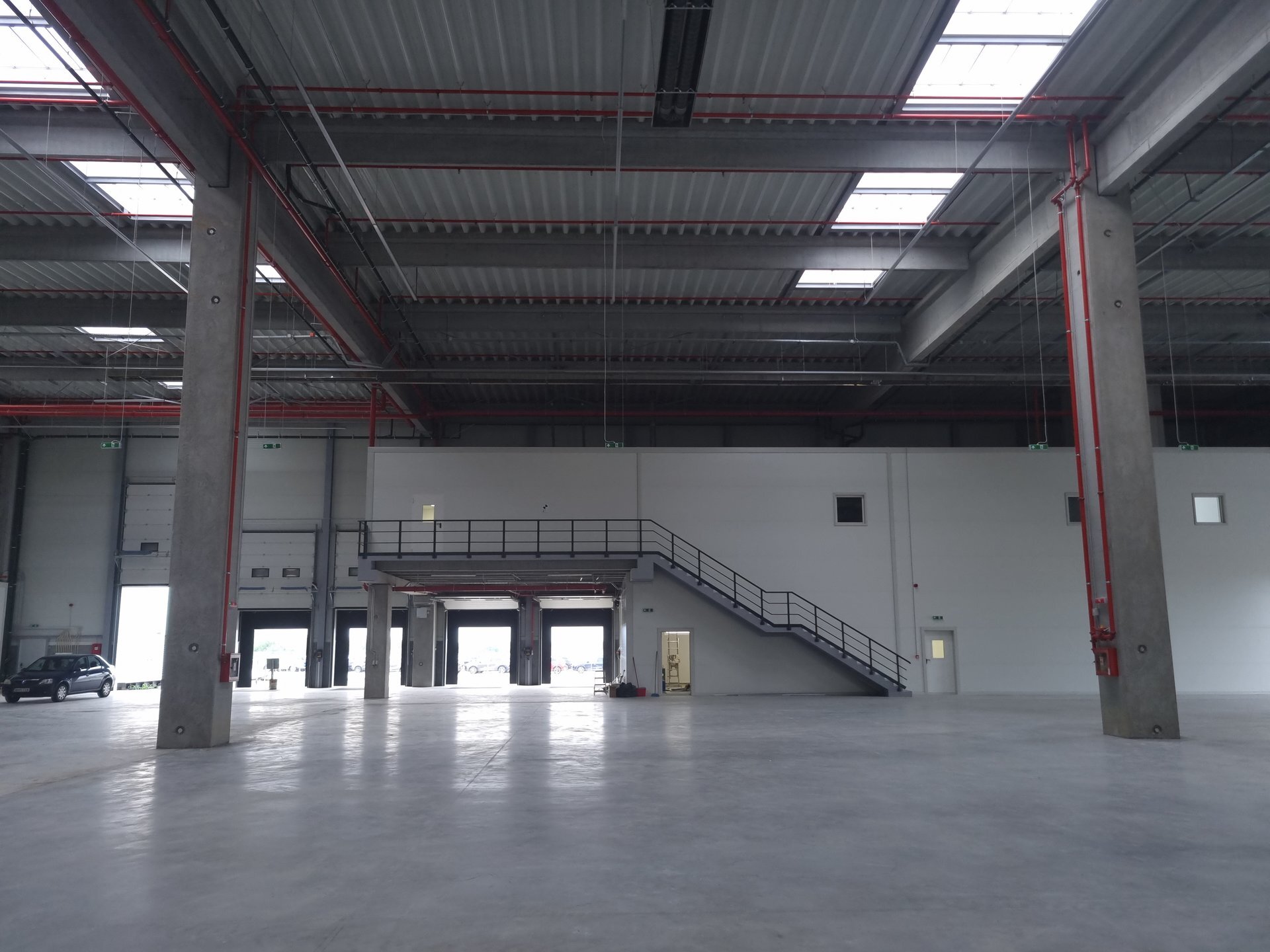 Interior hală logistică Espack Malu Mare cu mezanin metalic și porți de andocare în fundal, proiect PPAE