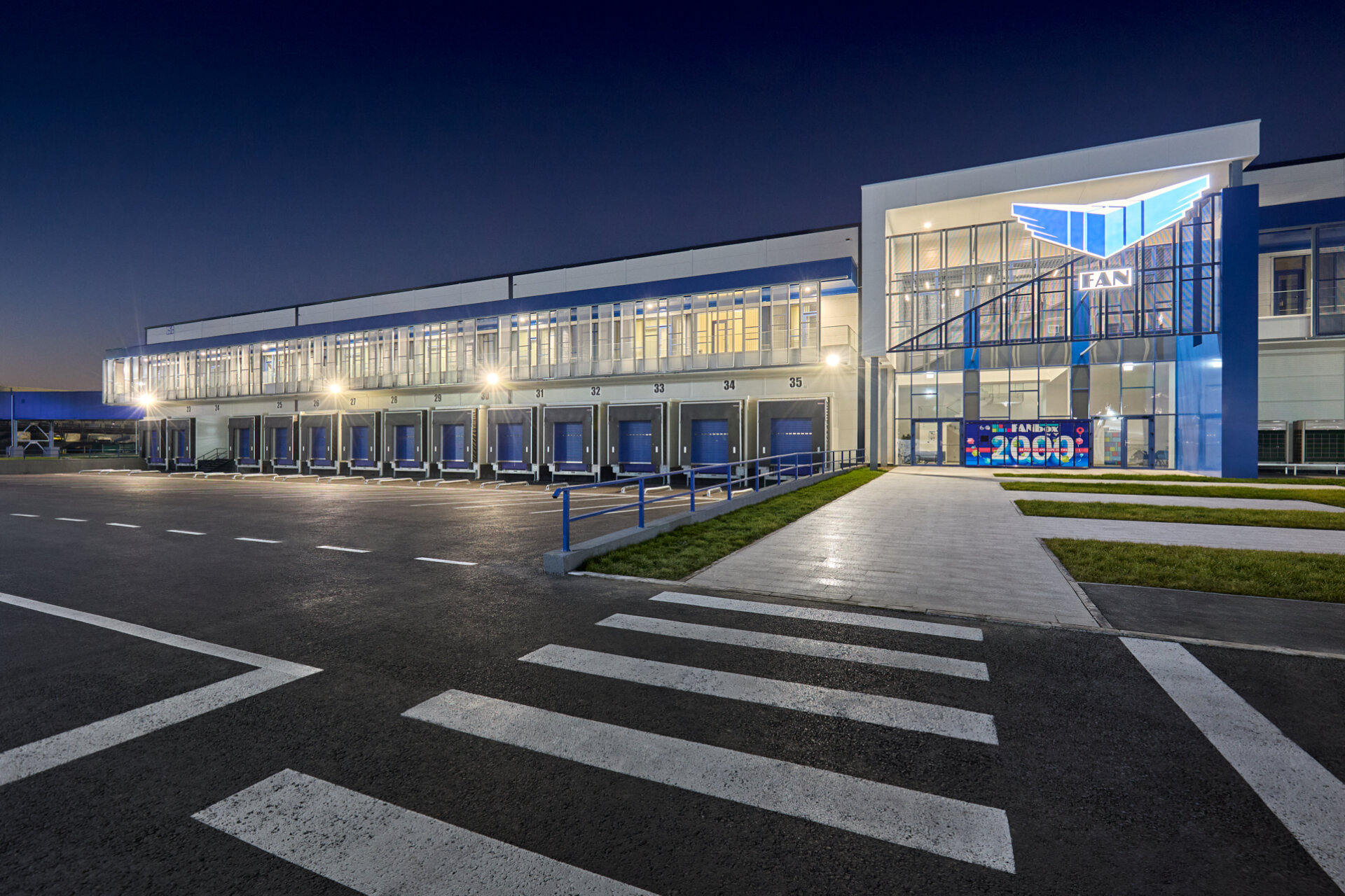 Fațadă principală nocturnă hub logistic FAN Courier Ștefănești cu zonă de andocare iluminată, proiect PPAE